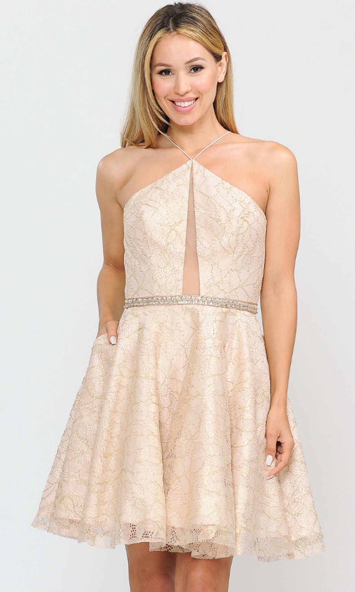 A woman wears the Glitter-Mesh Short A-Line Homecoming Dress 8506 in champagne, featuring a sleeveless halter neckline, front keyhole cutout, fitted waist, and flared skirt, standing against a plain background.